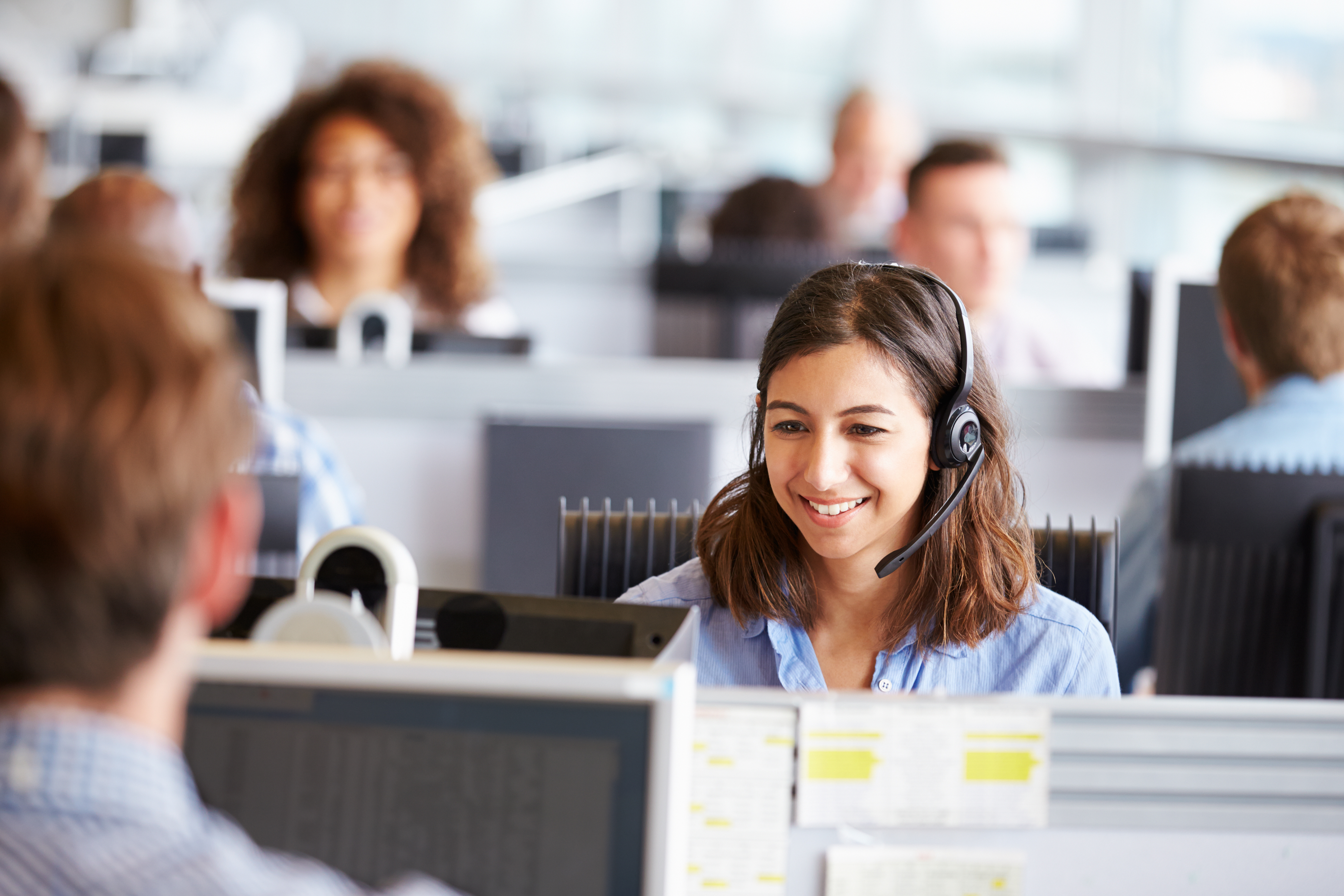 A female customer service representative handles a call over a headset.